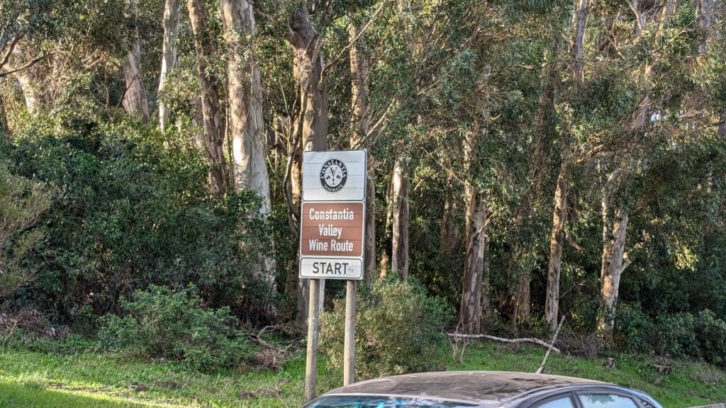 a sign on a pole in front of trees