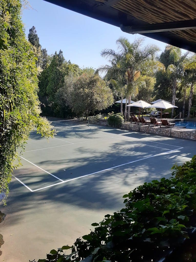 a tennis court with white lines and umbrellas