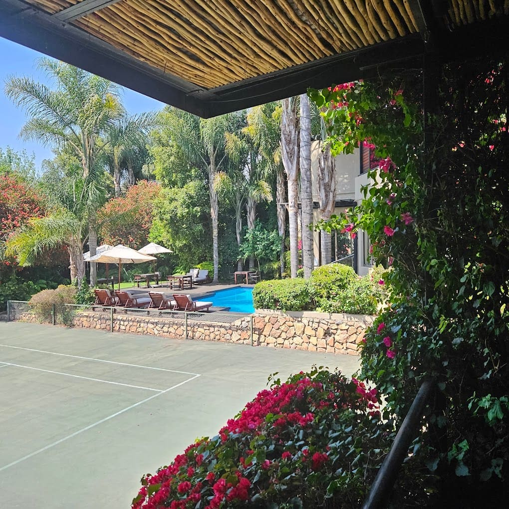 a tennis court with a pool and chairs