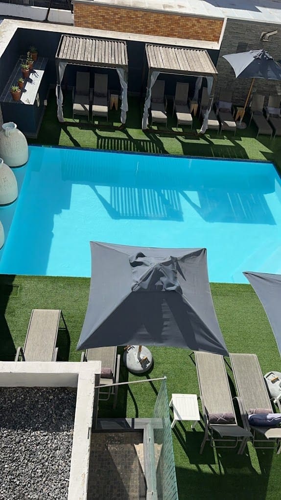 a pool with chairs and umbrellas