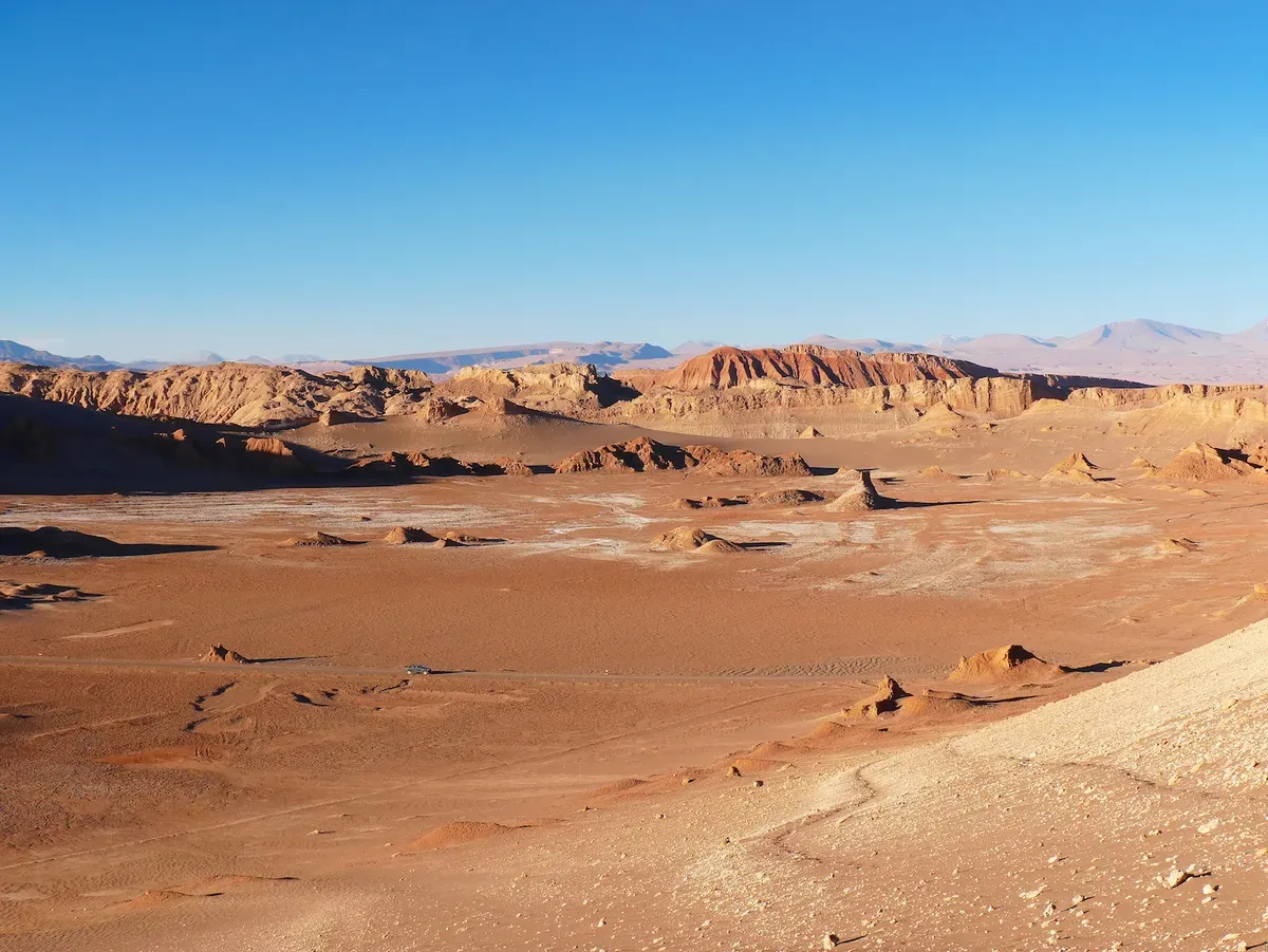 a desert landscape with rocky hills and blue sky