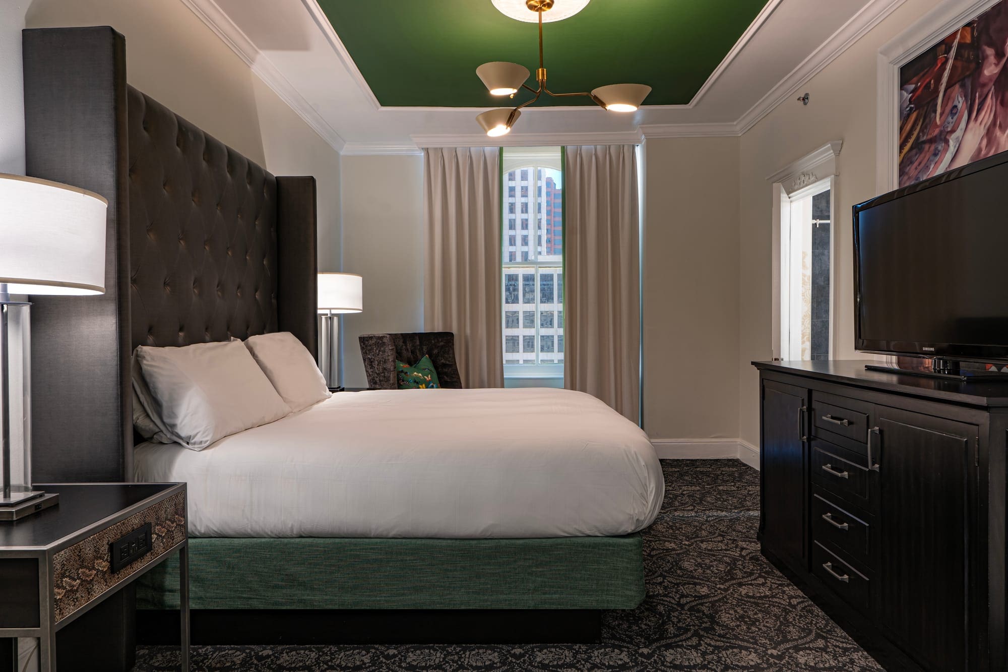 a bedroom with a green ceiling and a white bed
