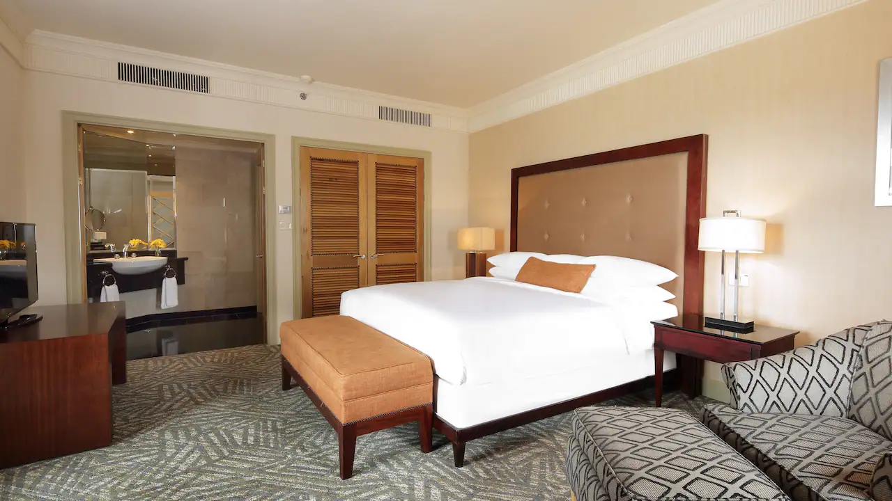 a bedroom with a bed and a stool