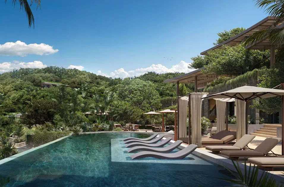 a pool with lounge chairs and trees in the background