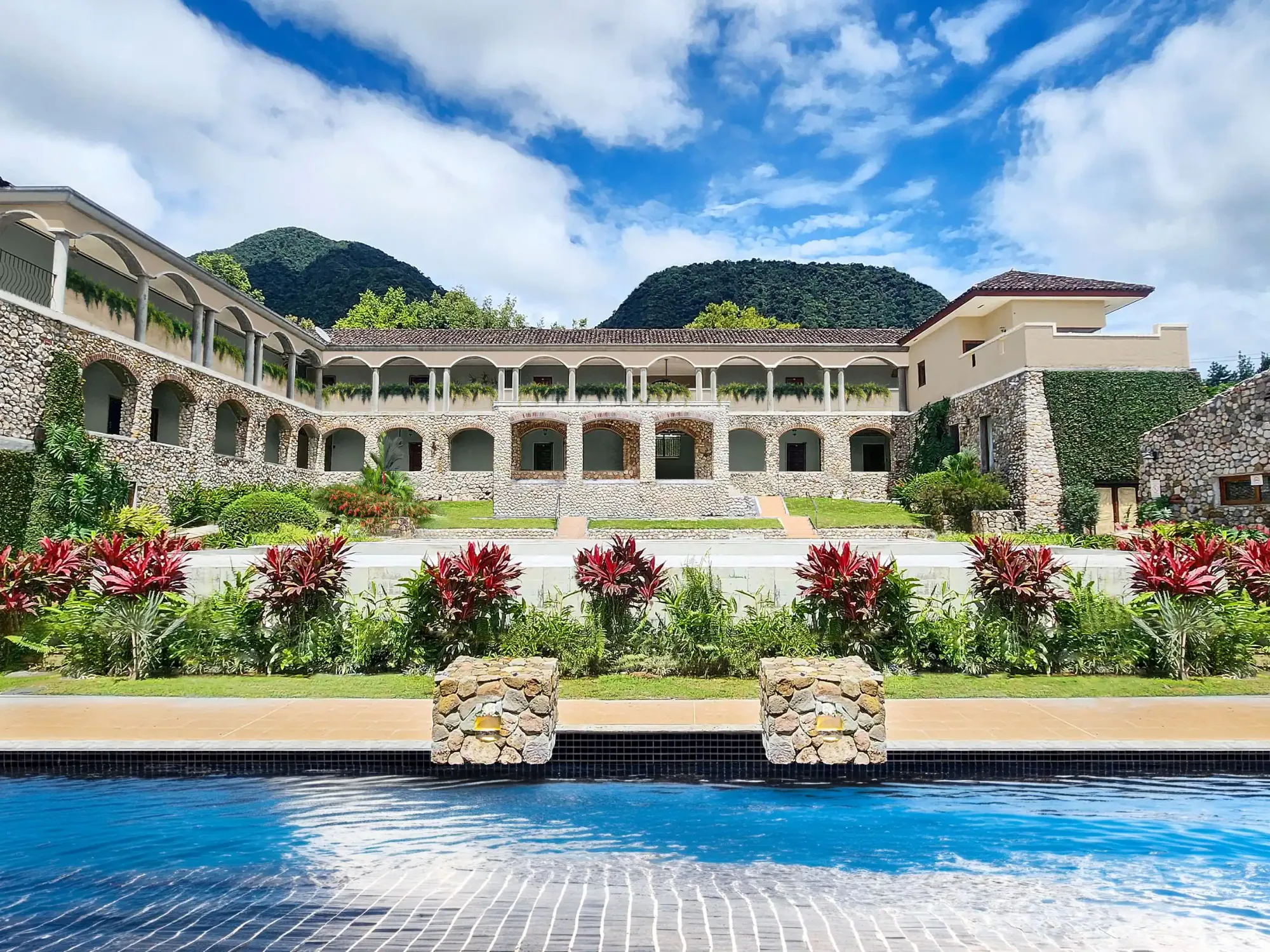 a pool with a building and a mountain in the background