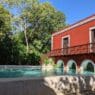 a red building with a pool and a bridge