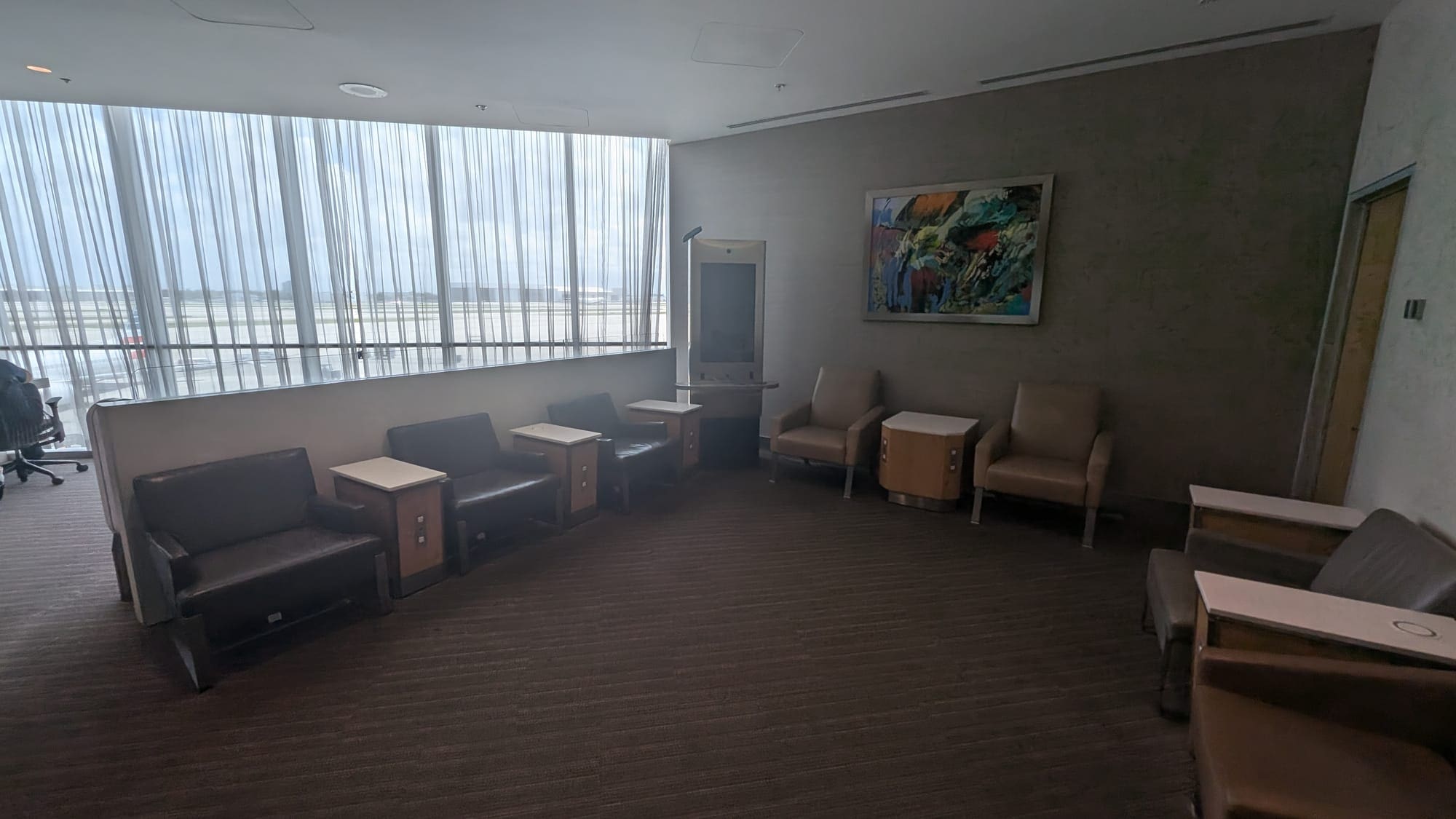 a room with chairs and a painting on the wall