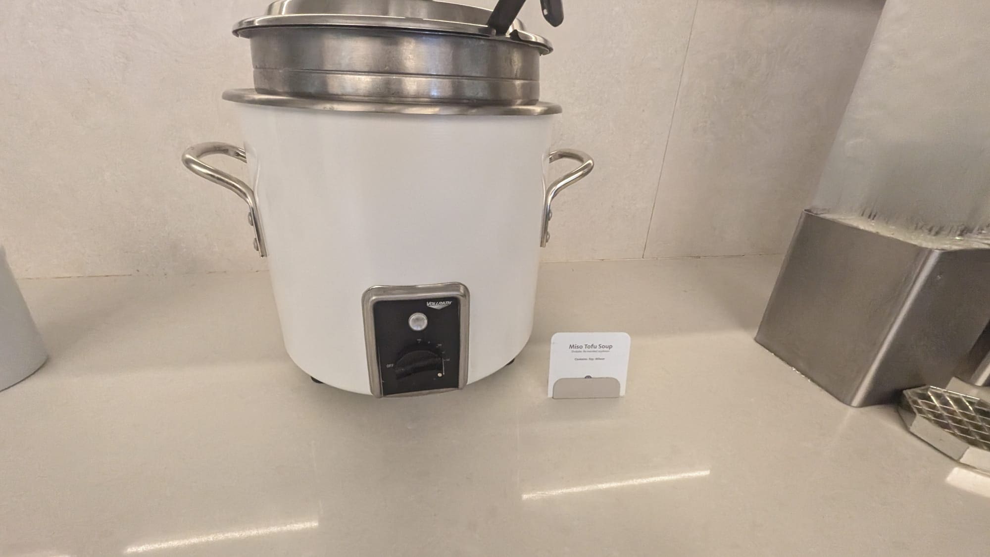 a large white pot with a lid and a white sign
