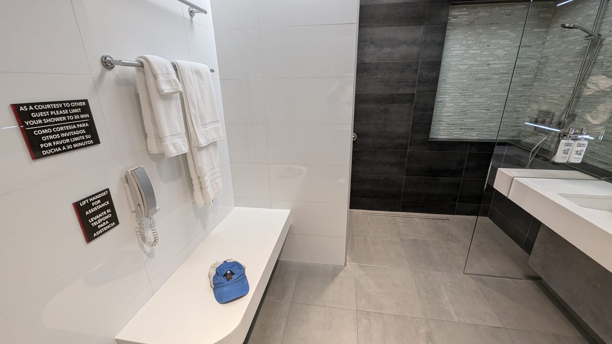 a white bench with a hat on it in a bathroom