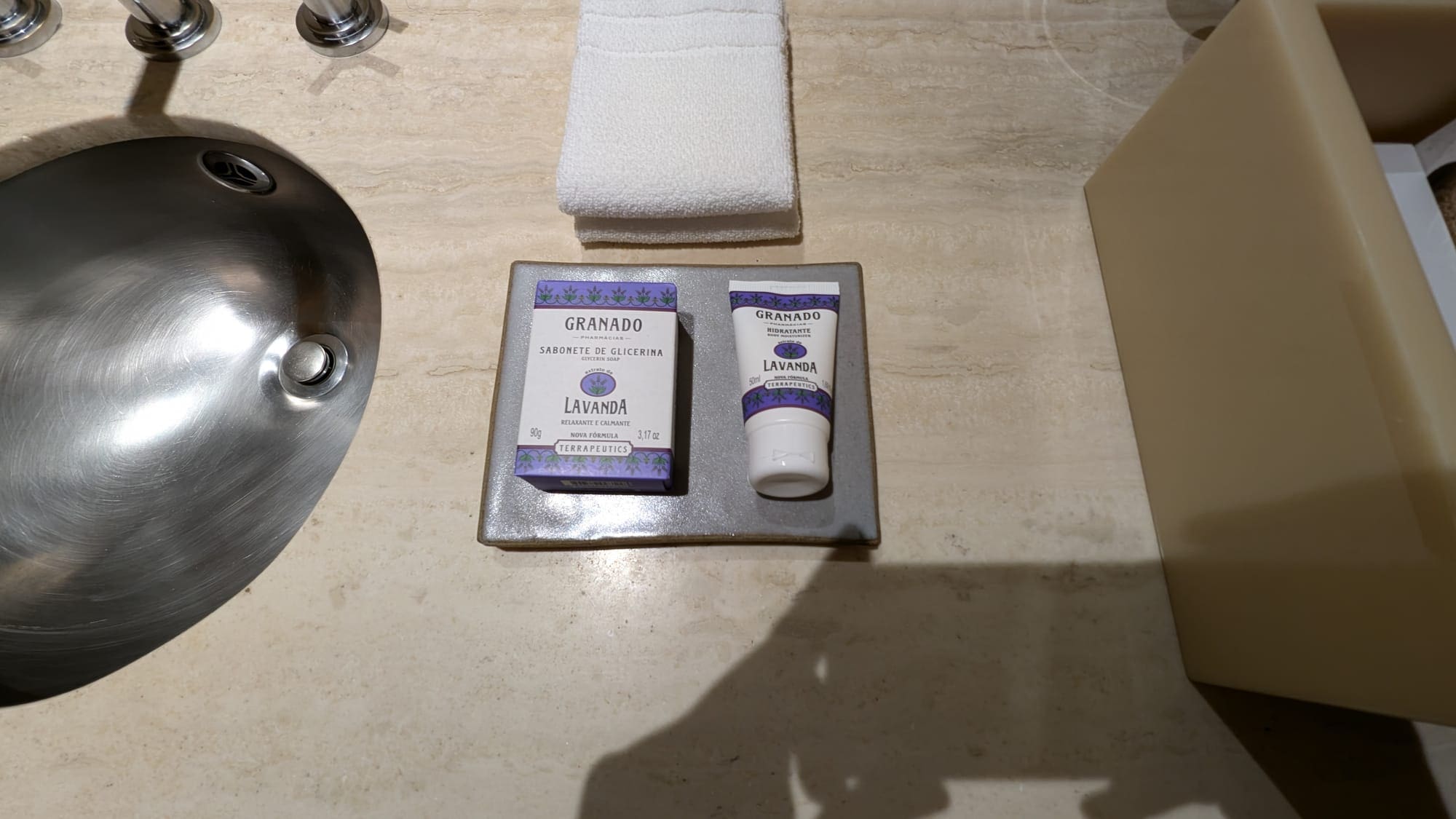 a bathroom sink with a towel and a bottle of soap