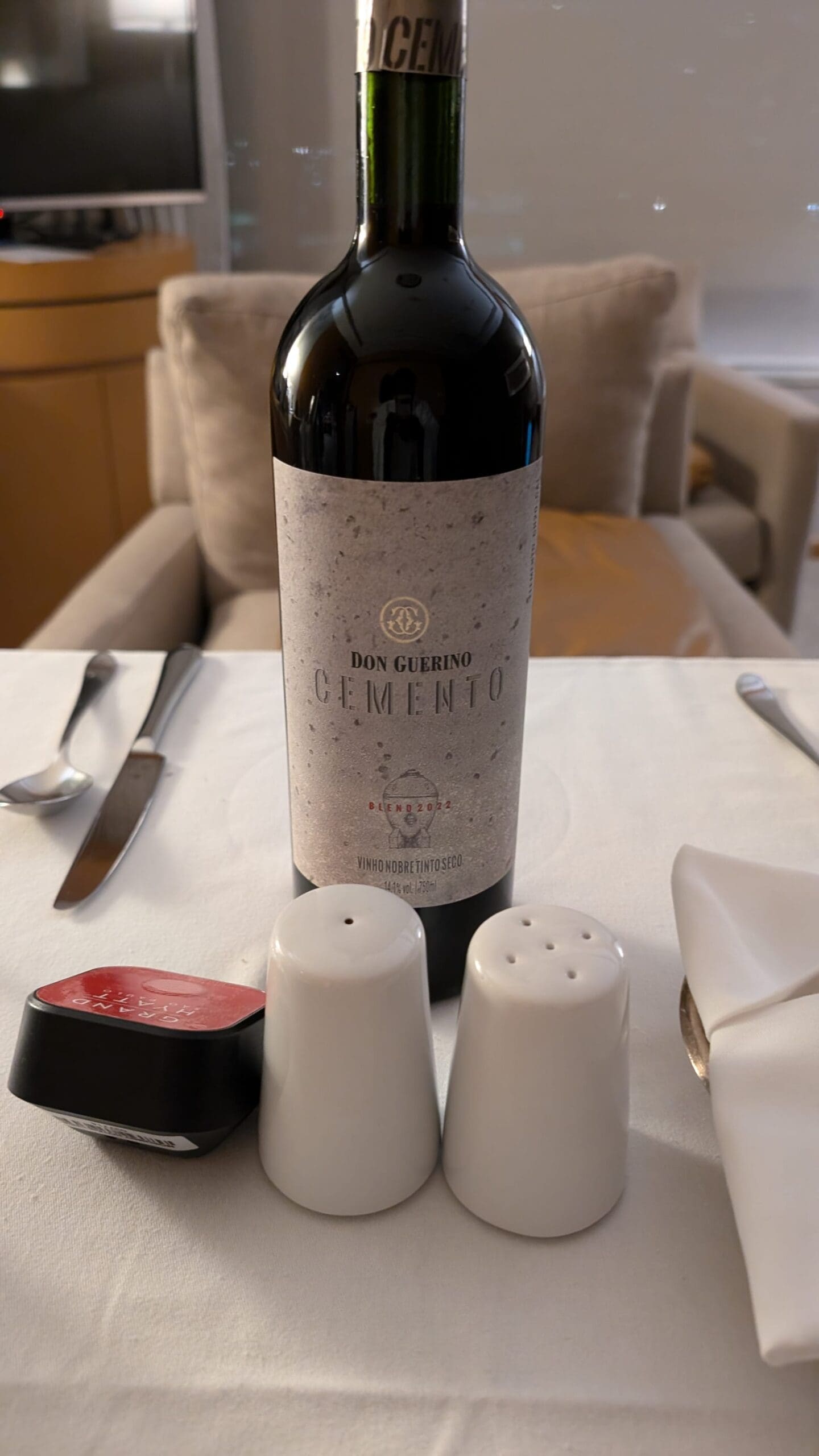 a bottle of wine next to salt and pepper shakers