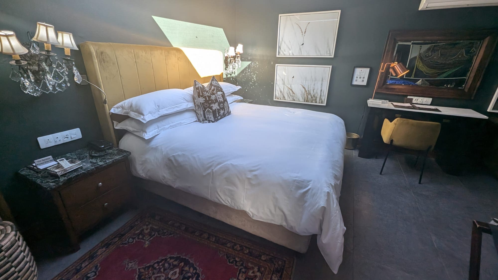 a bed with pillows and a rug in a room