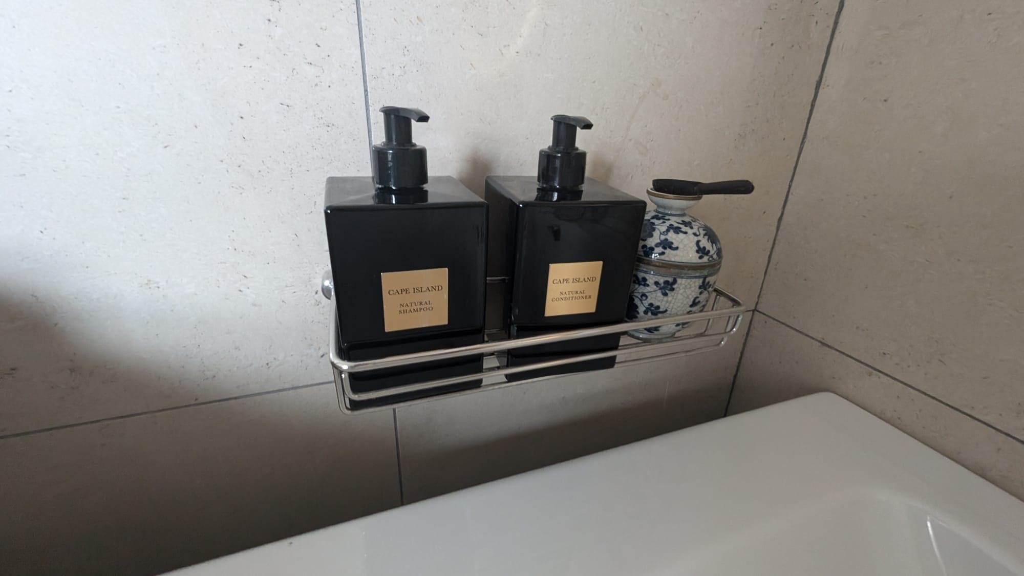 a couple of black bottles on a metal shelf