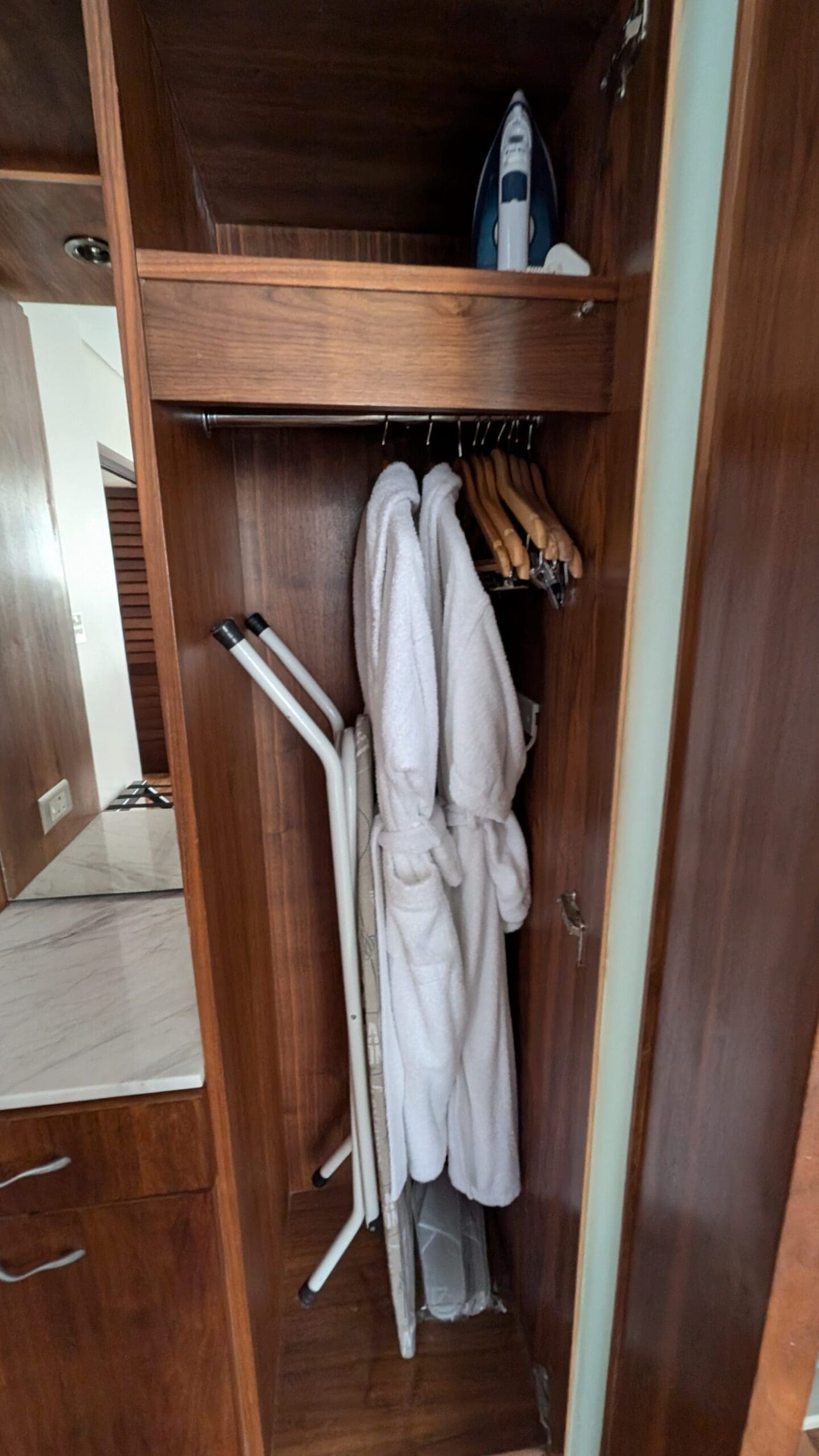 a closet with white robe and swingers