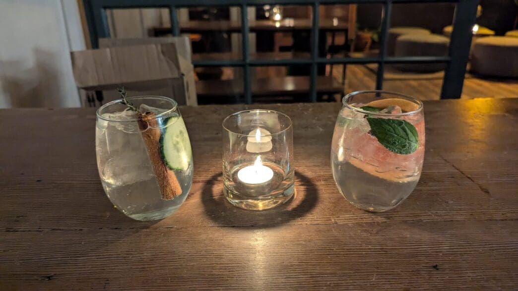 a group of glasses with liquid and a candle on a table