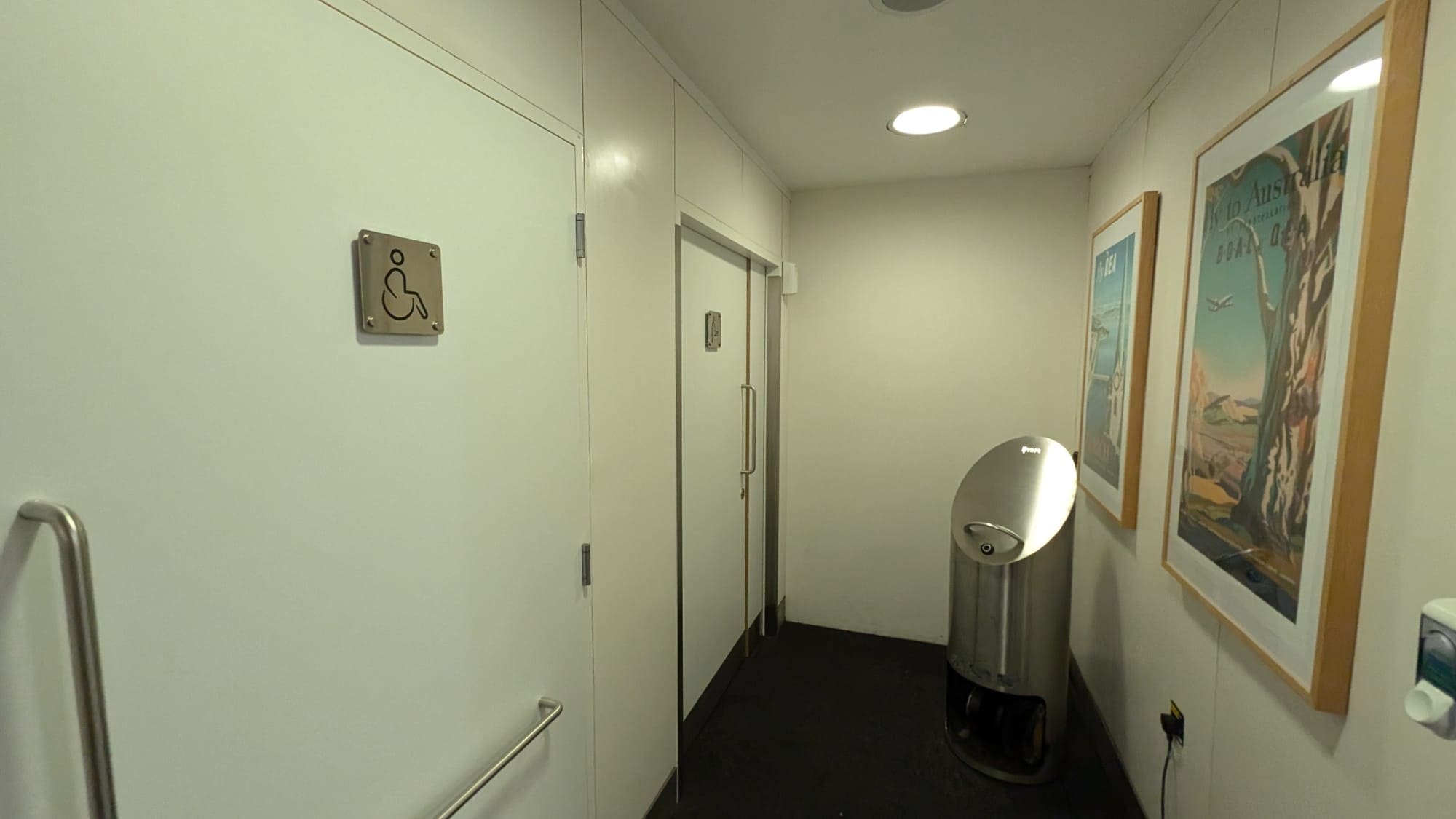 a bathroom with a trash can and doors