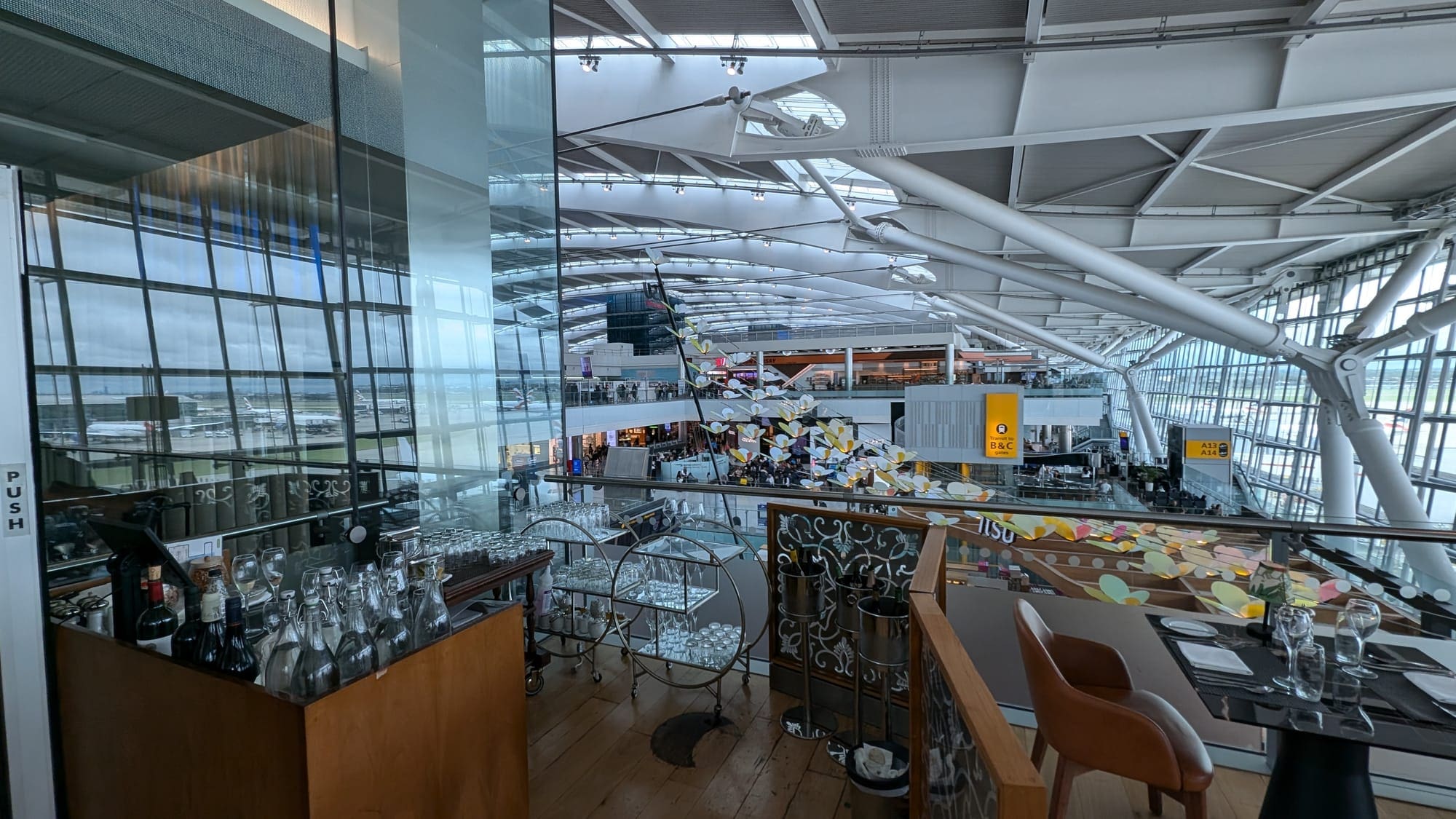a glass ceiling with a bar and chairs