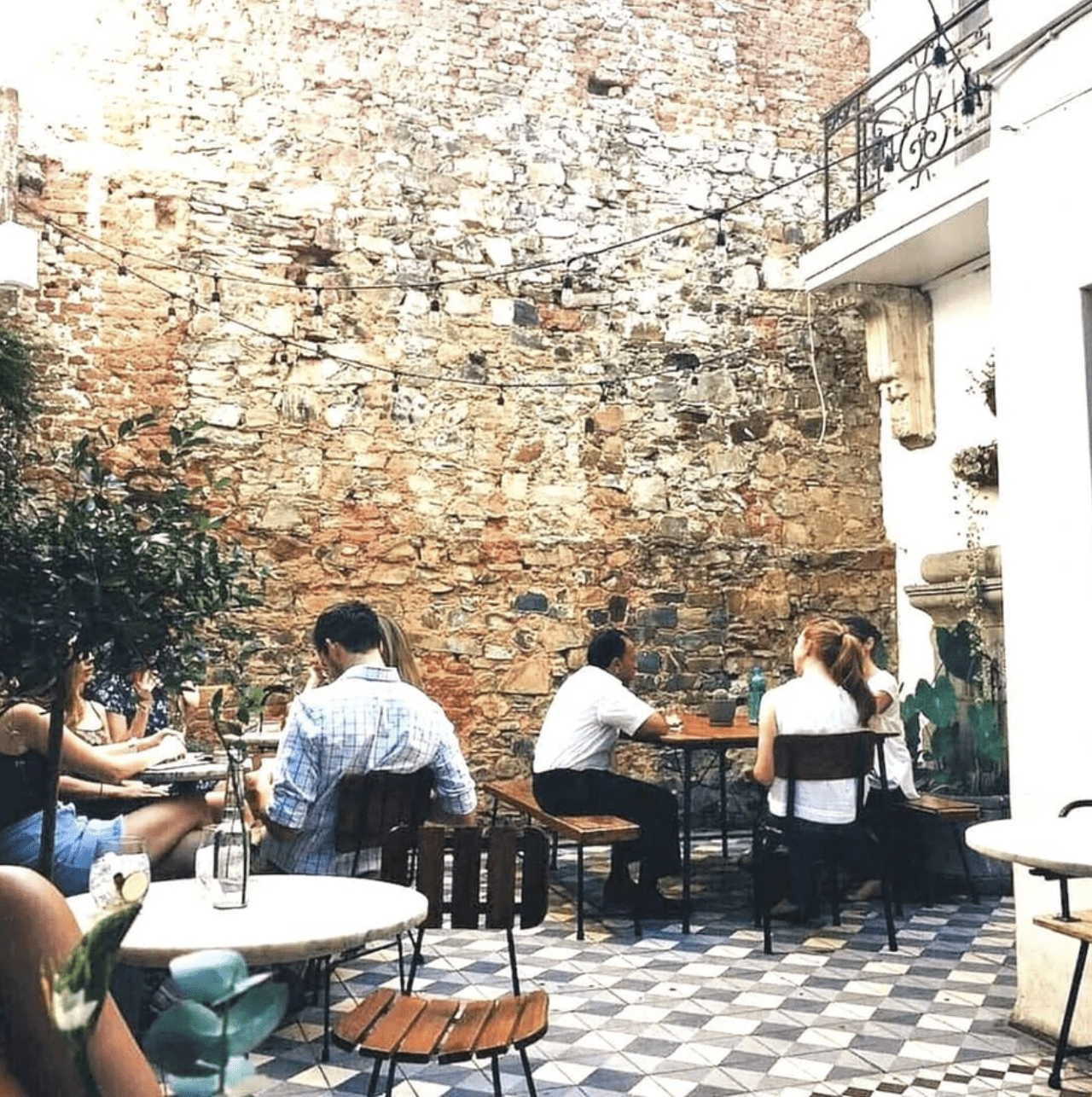 a group of people sitting at tables outside