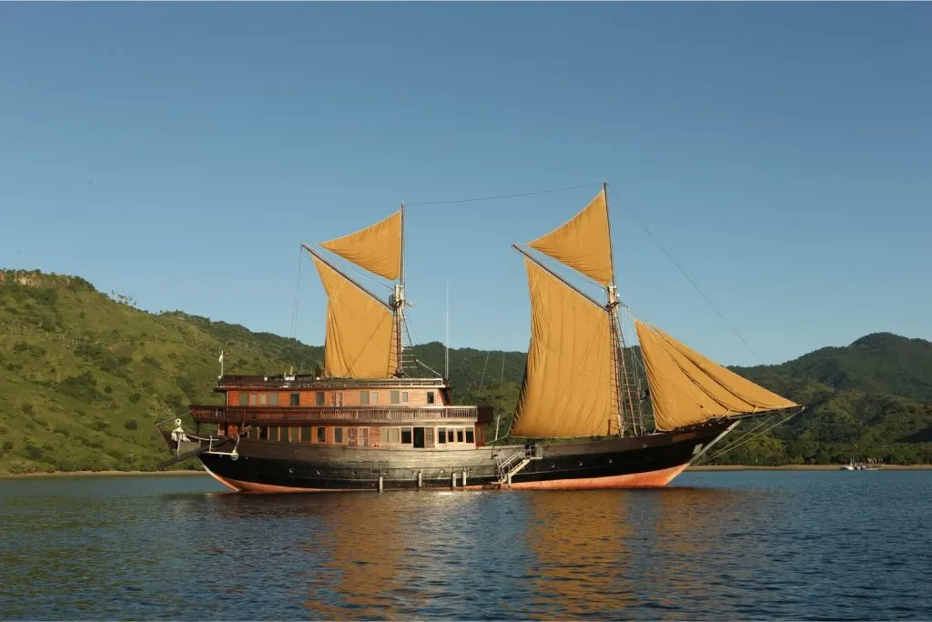 a boat with yellow sails on water