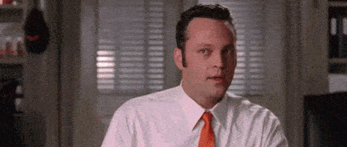 a man in a white shirt and orange tie