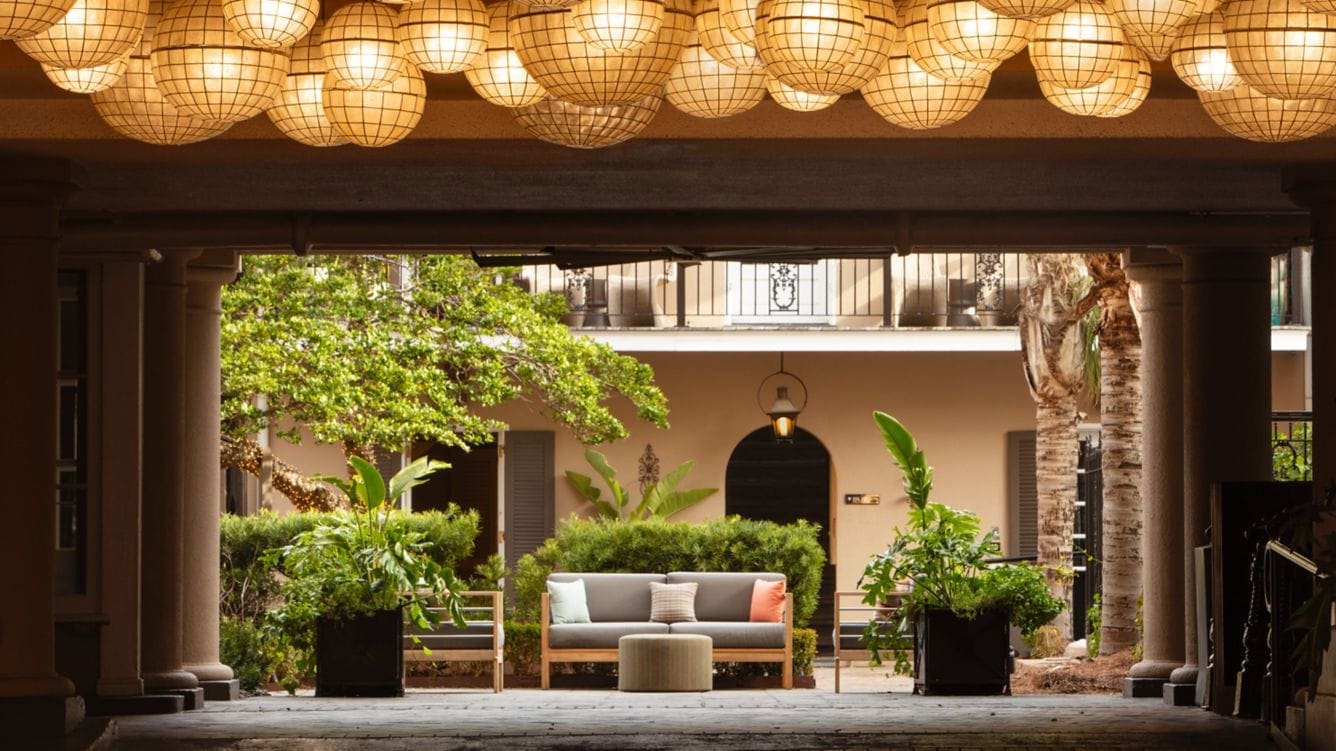 a patio with a couch and a bench and a round light fixture