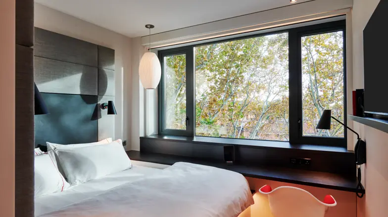 a bed with a white bedding and a white lamp