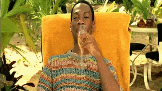 a man sitting in a chair drinking from a glass