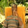 a man sitting in a chair drinking from a glass