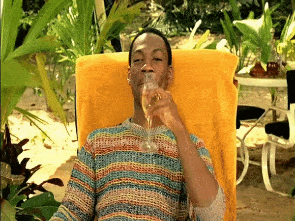a man sitting in a chair drinking from a glass