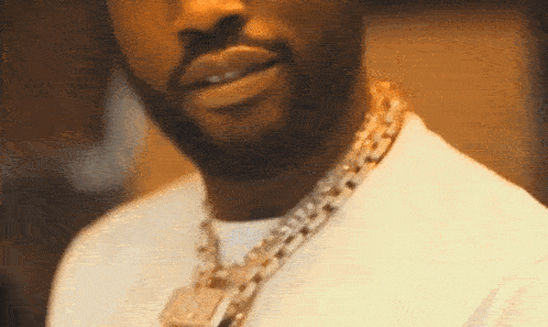 a man wearing a white shirt and a gold chain