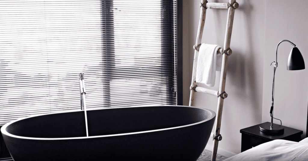 a black bathtub next to a window