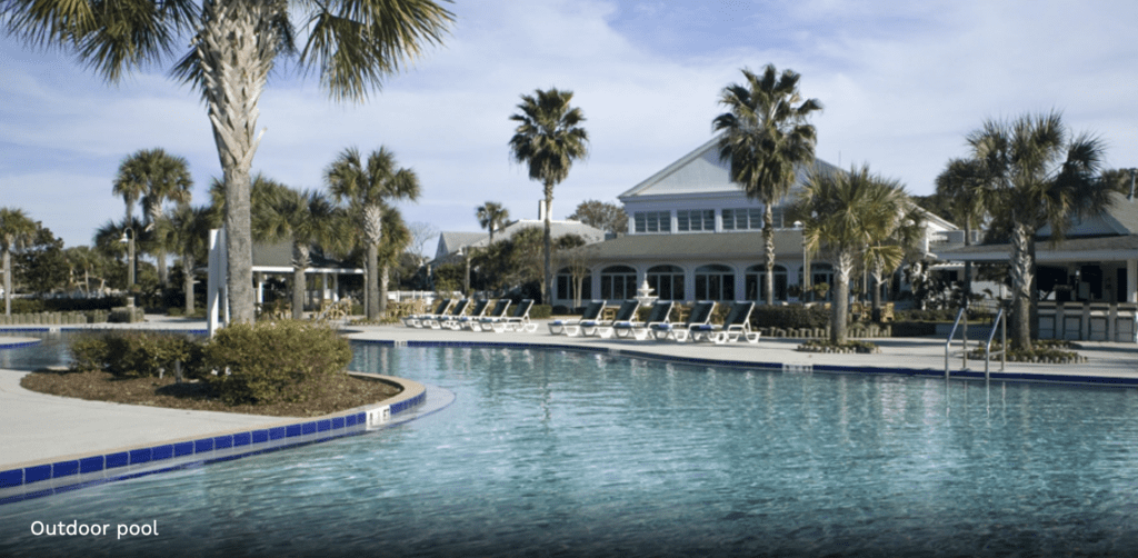a pool with lounge chairs and palm trees