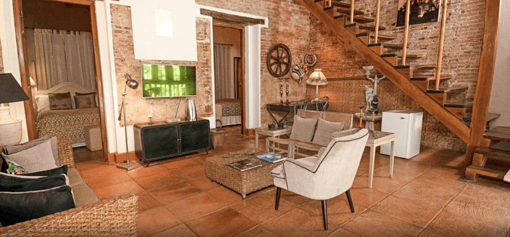 a living room with a brick wall and a couch and a television