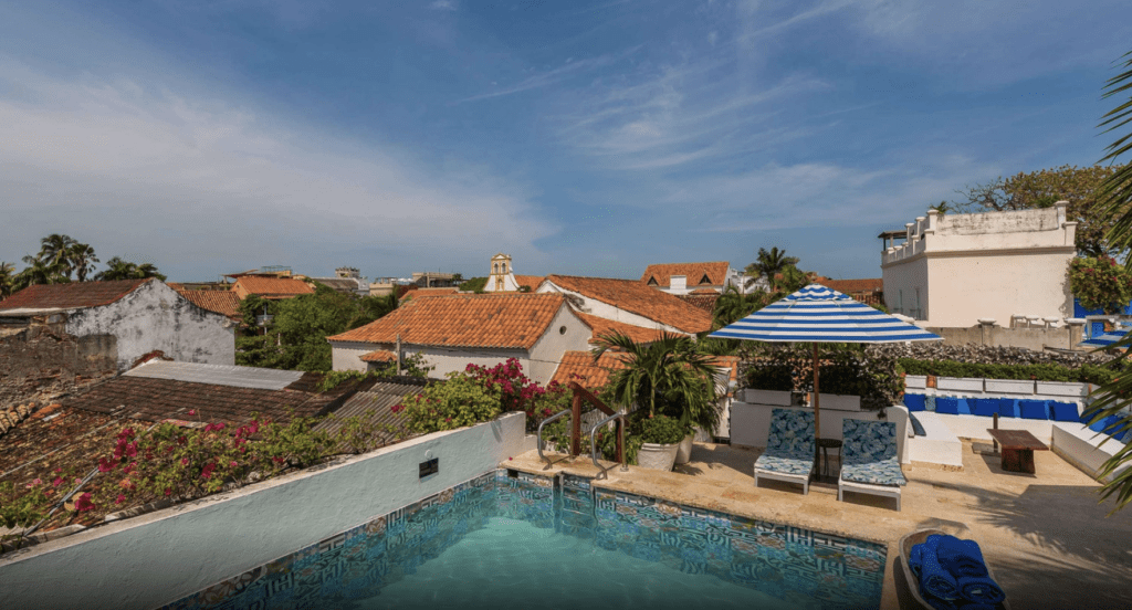 a pool with chairs and umbrellas in a rooftop