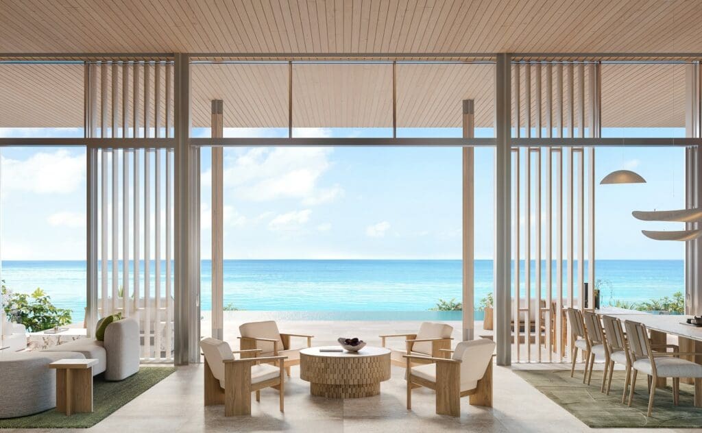 a room with a table and chairs and a view of the ocean