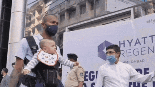 a man carrying a baby in a carrier