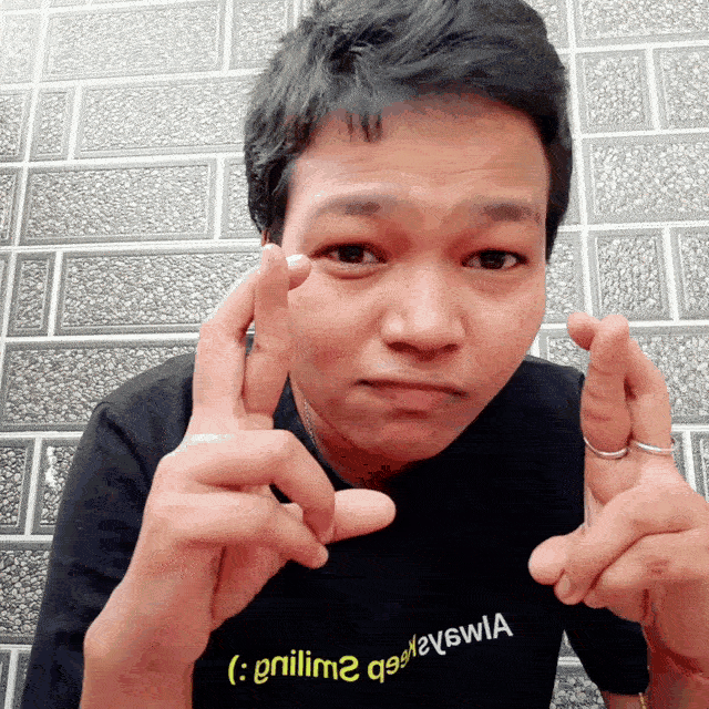 a boy making a face with his fingers