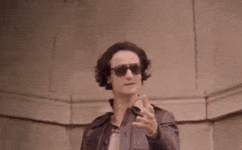 a man wearing sunglasses and holding a gun