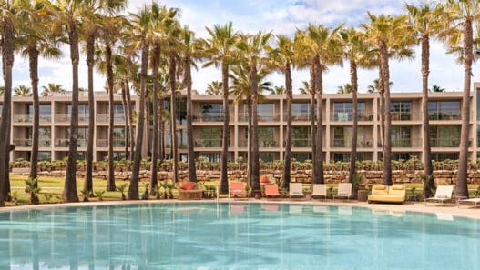 a pool with palm trees and chairs