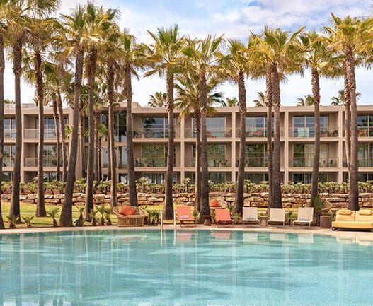 a pool with palm trees and chairs