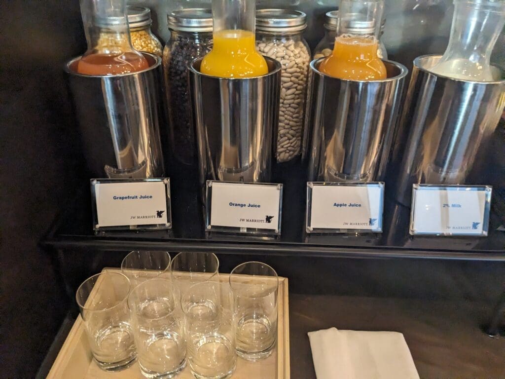 a shelf with different types of juices and glasses