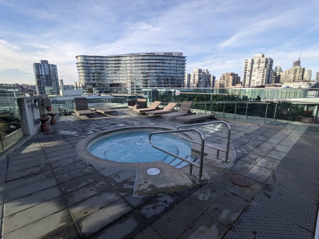 a hot tub with a railing and a city skyline