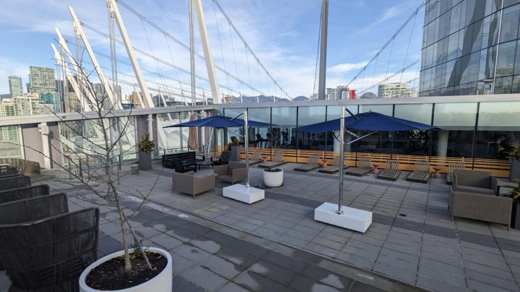 a patio with umbrellas and chairs on a rooftop