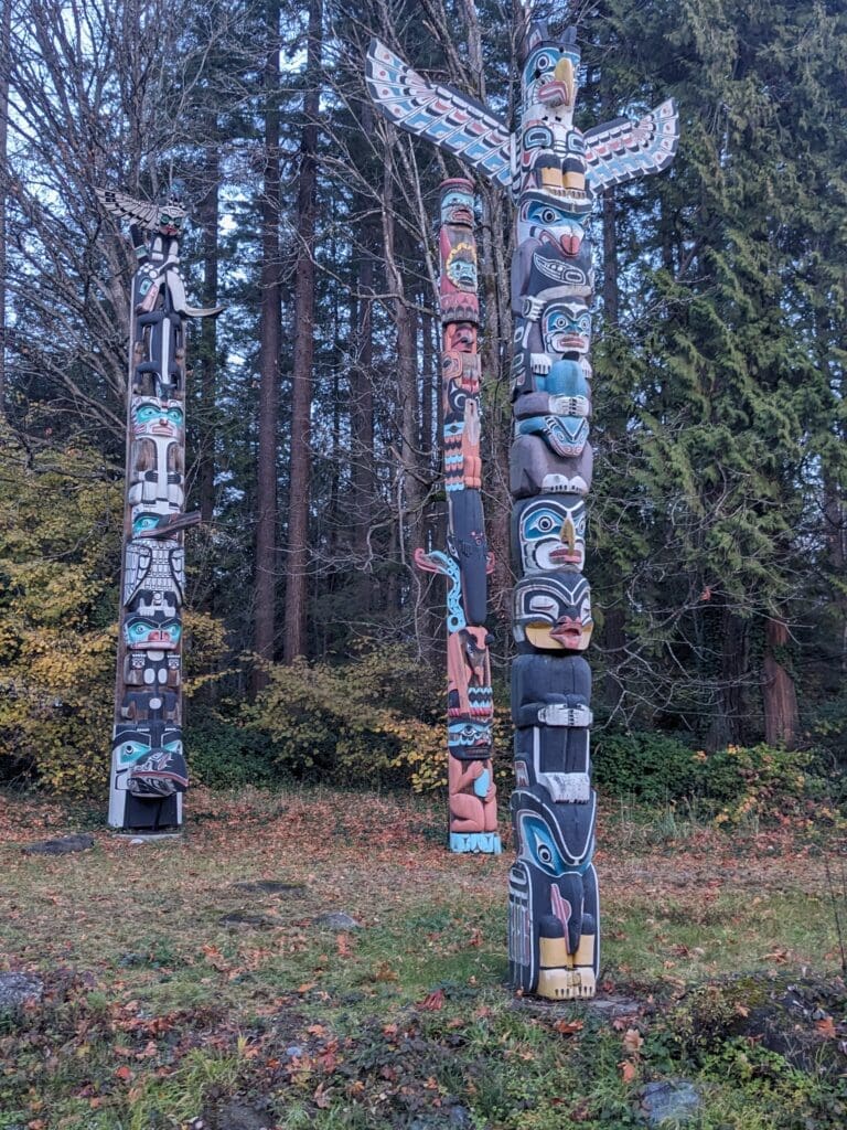 a group of totem poles in a forest