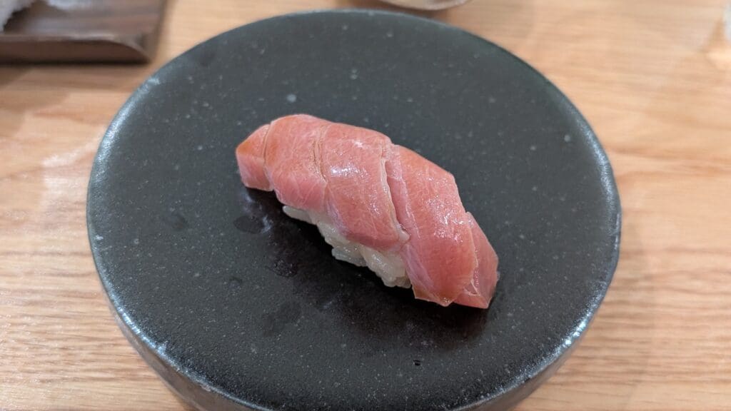 a piece of raw fish on a black plate