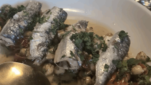 a bowl of fish with a spoon