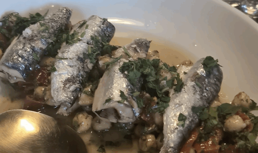 a bowl of fish with a spoon