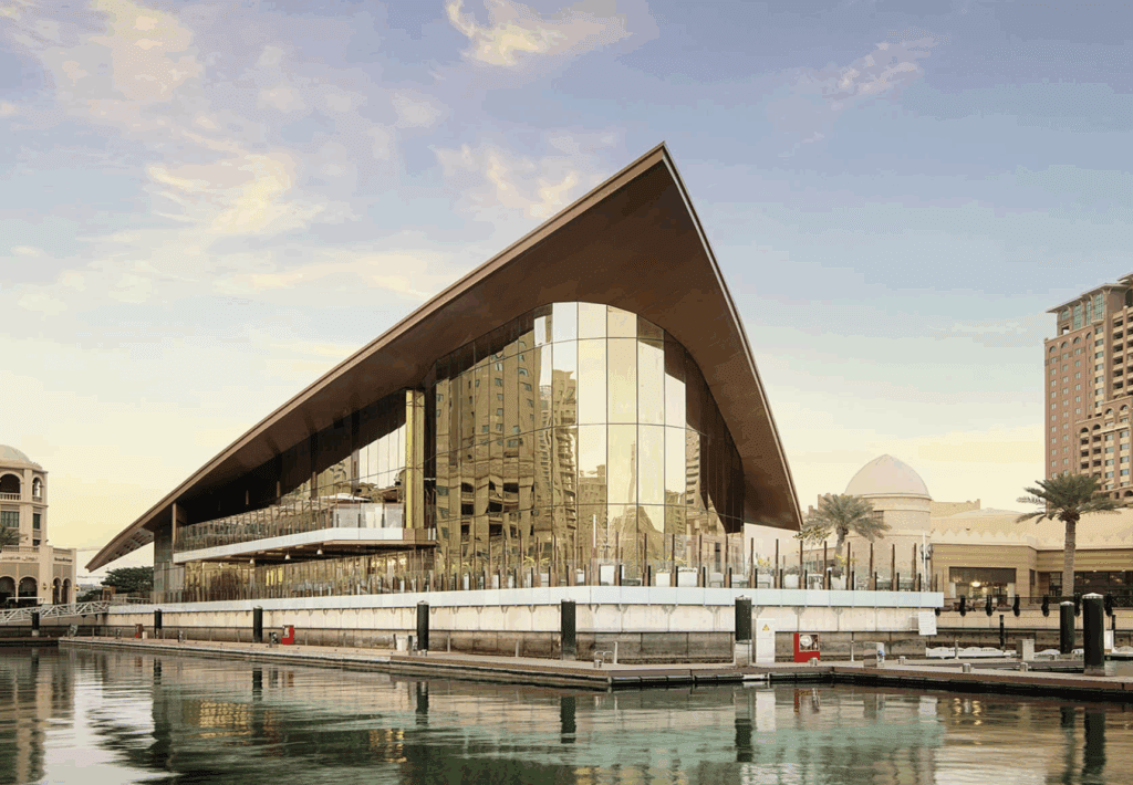 a building with a triangular roof and glass walls