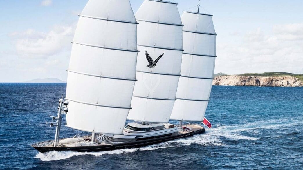 a sailboat with white sails on water