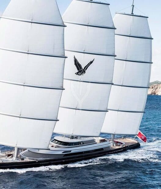 a sailboat with white sails on water